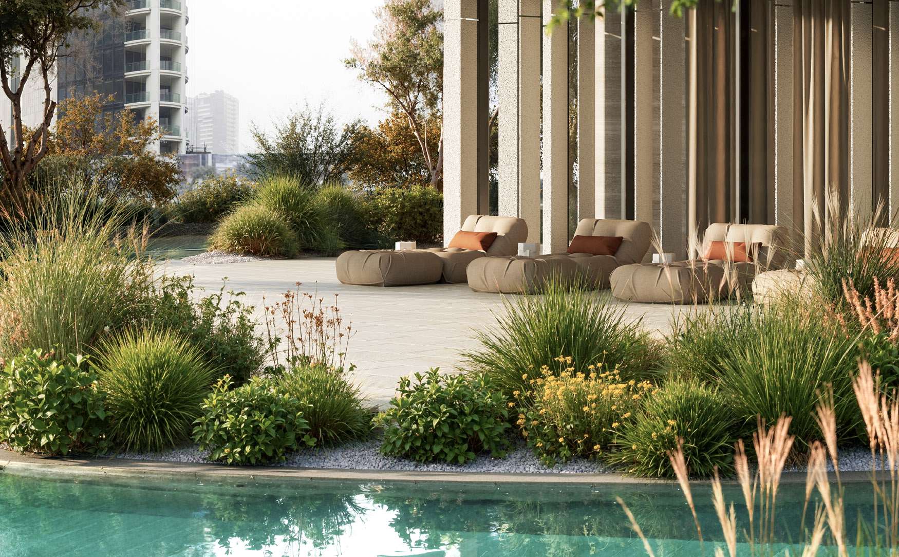 Pool edge with grasses and lounge seating under a shaded colonnade